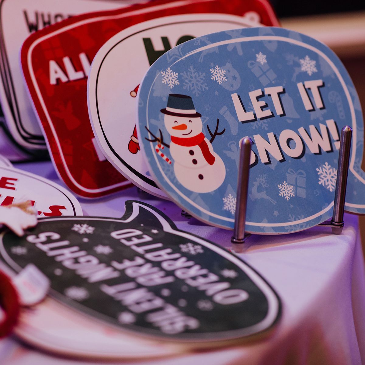 Christmas-themed photo booth props featuring signs that say