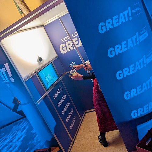 A blue photo booth branded with the word 