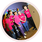 A group of five people wearing matching pink shirts and smiling together during an event.
