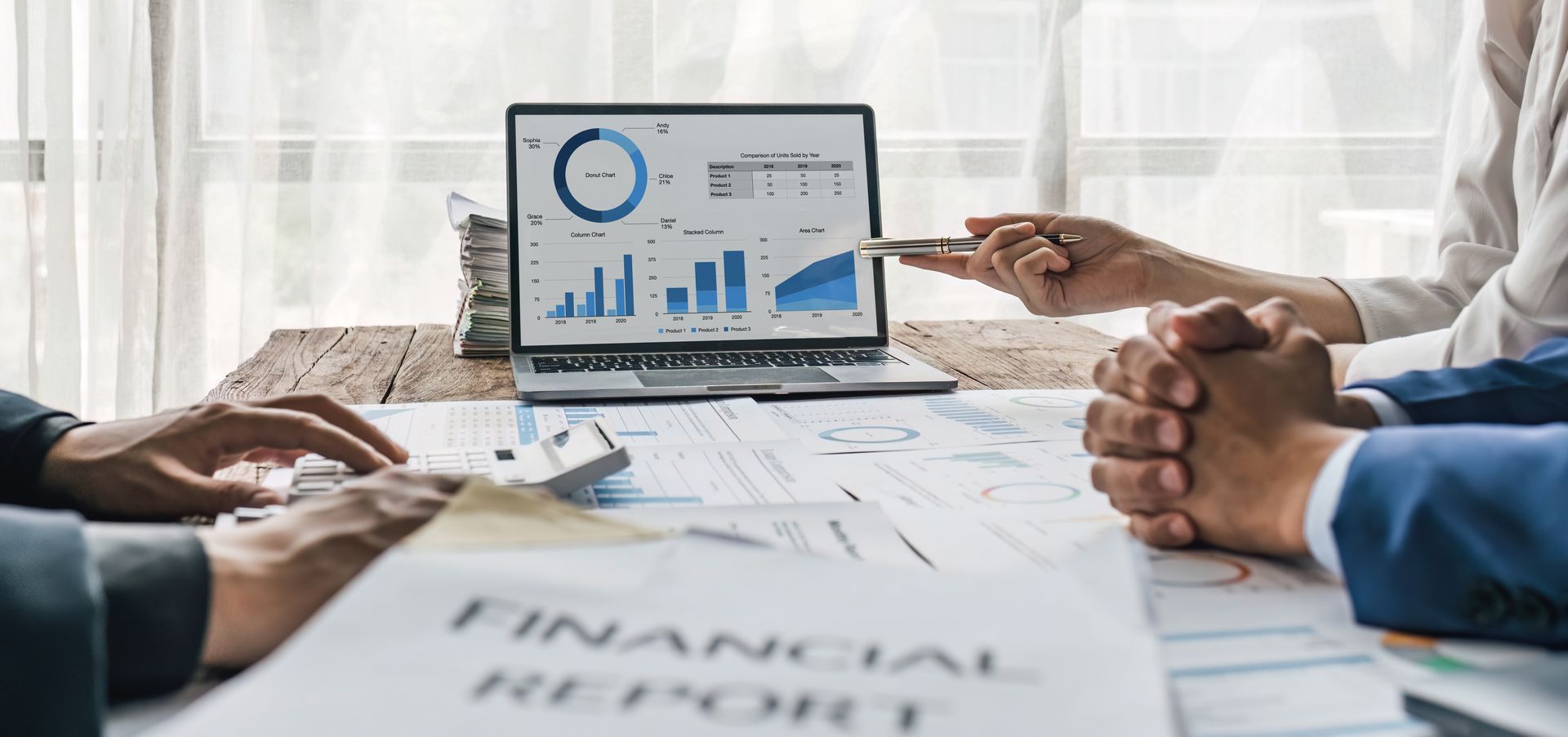 Business meeting with laptop financial charts and people discussing data over paperwork