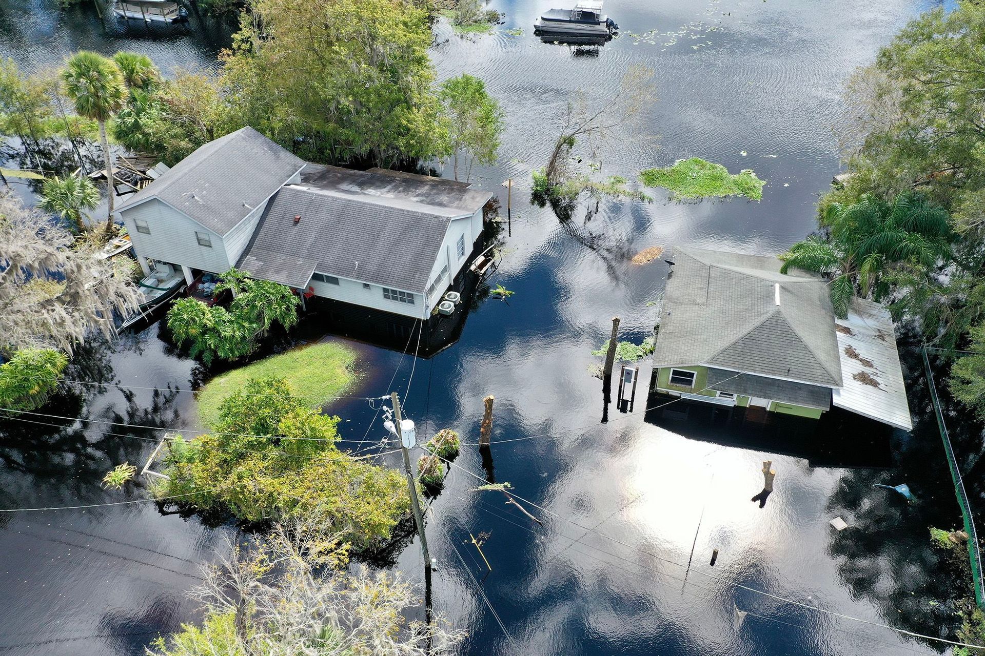 221011143630-04-florida-flooded-homes An aerial view of a flooded area with houses and trees