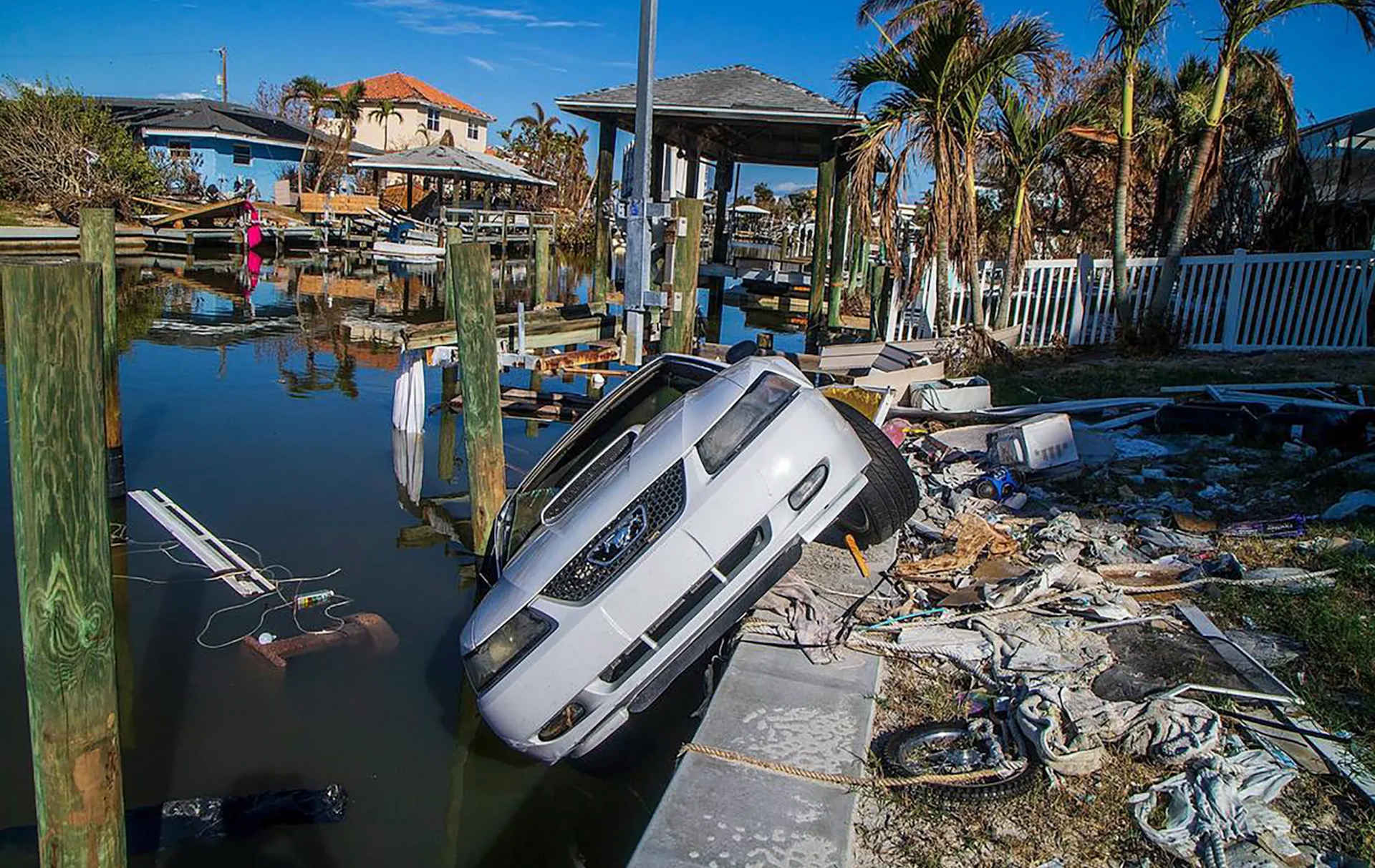 a car is laying on its side in a flooded area .