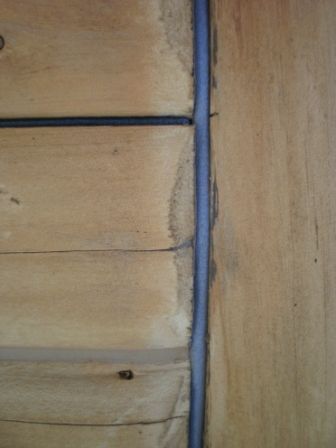 Wooden planks with a dark sealant in the corner.