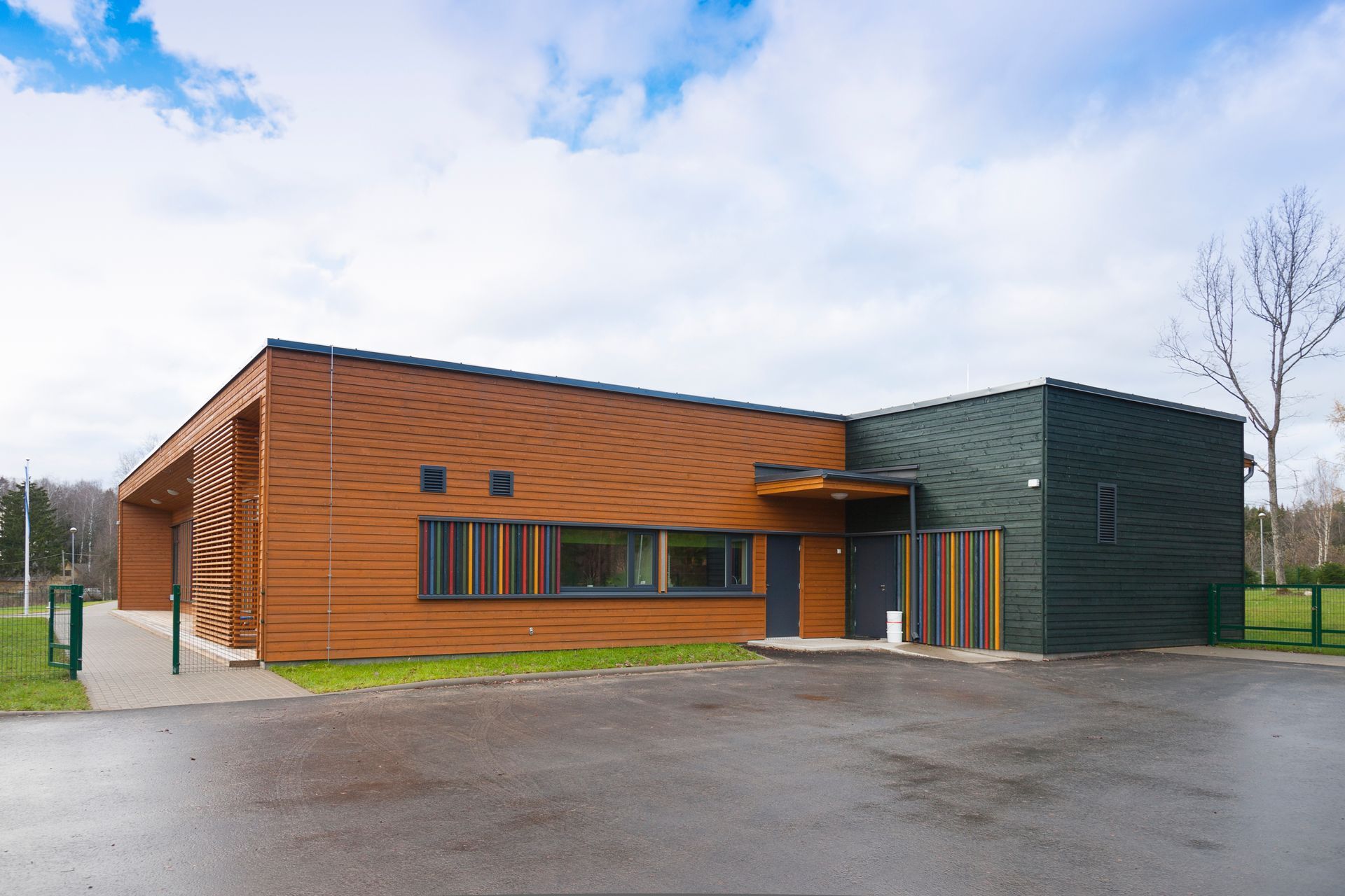 A large building with a lot of windows and a fence in front of it.
