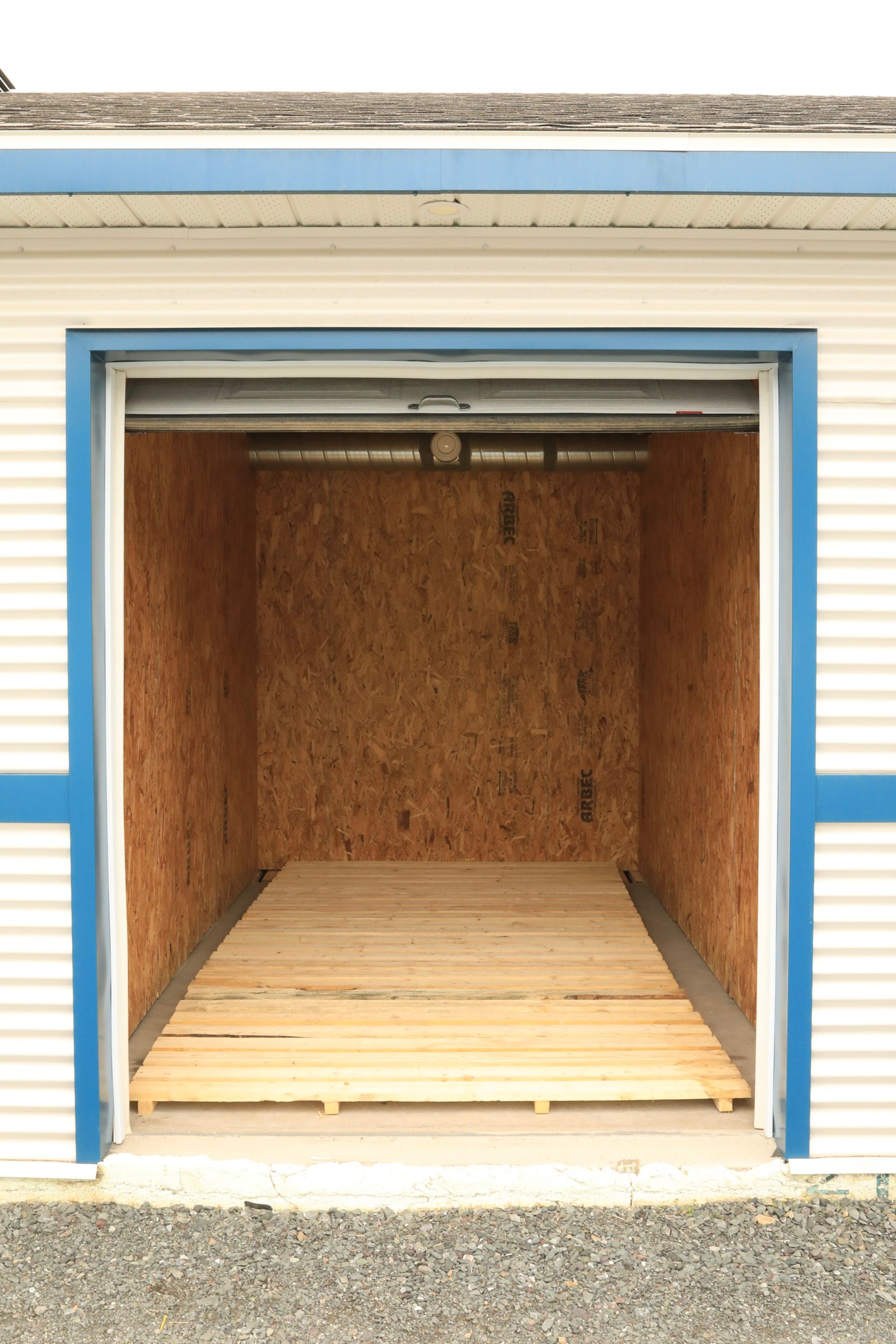 Un garage vide avec un plancher en bois et une garniture bleue.