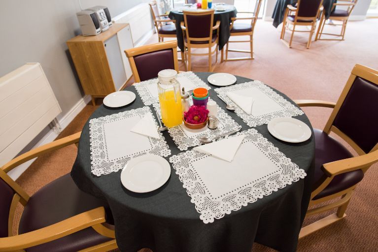 a round table with plates and a pitcher of orange juice on it
