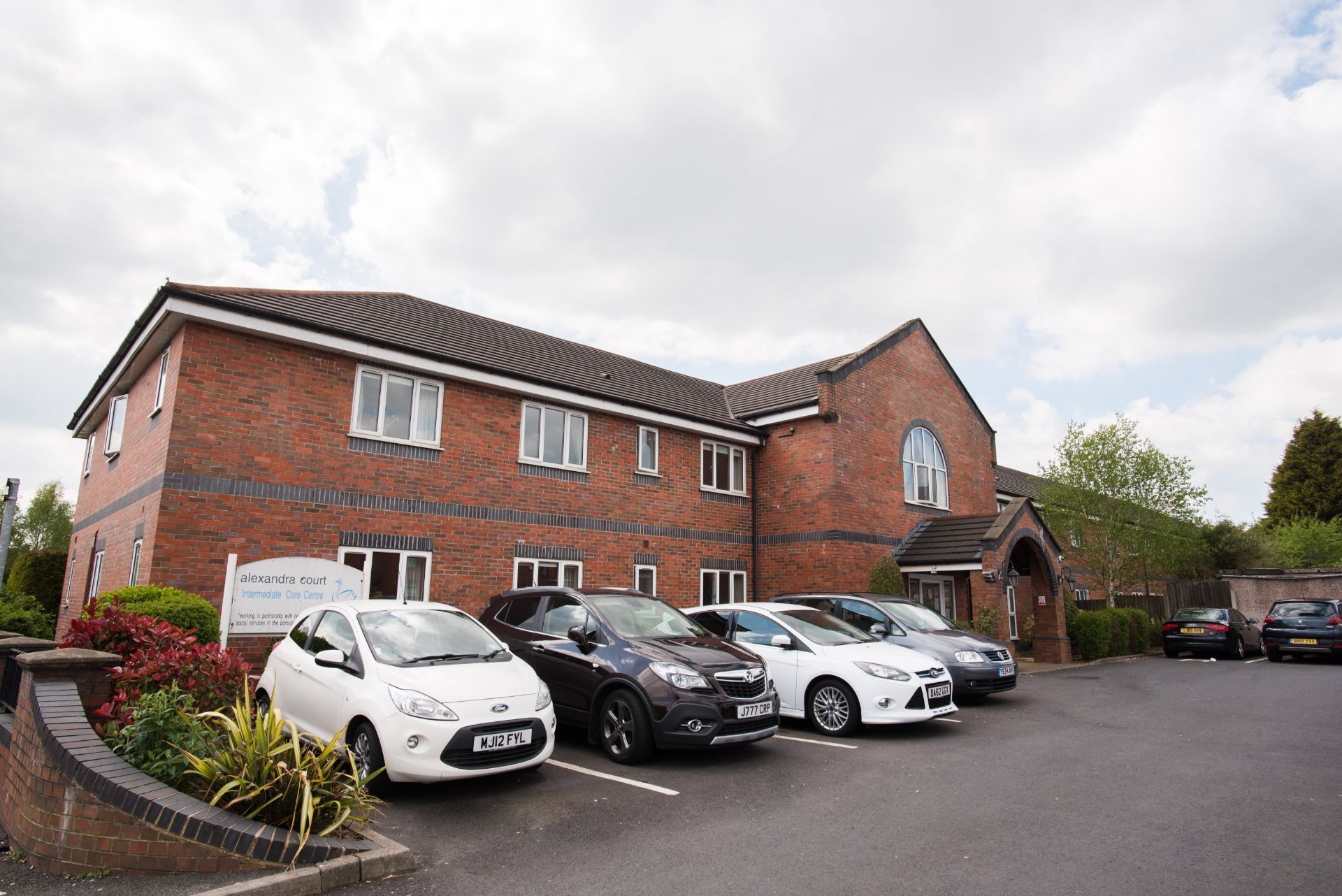 a row of cars are parked in front of a brick building