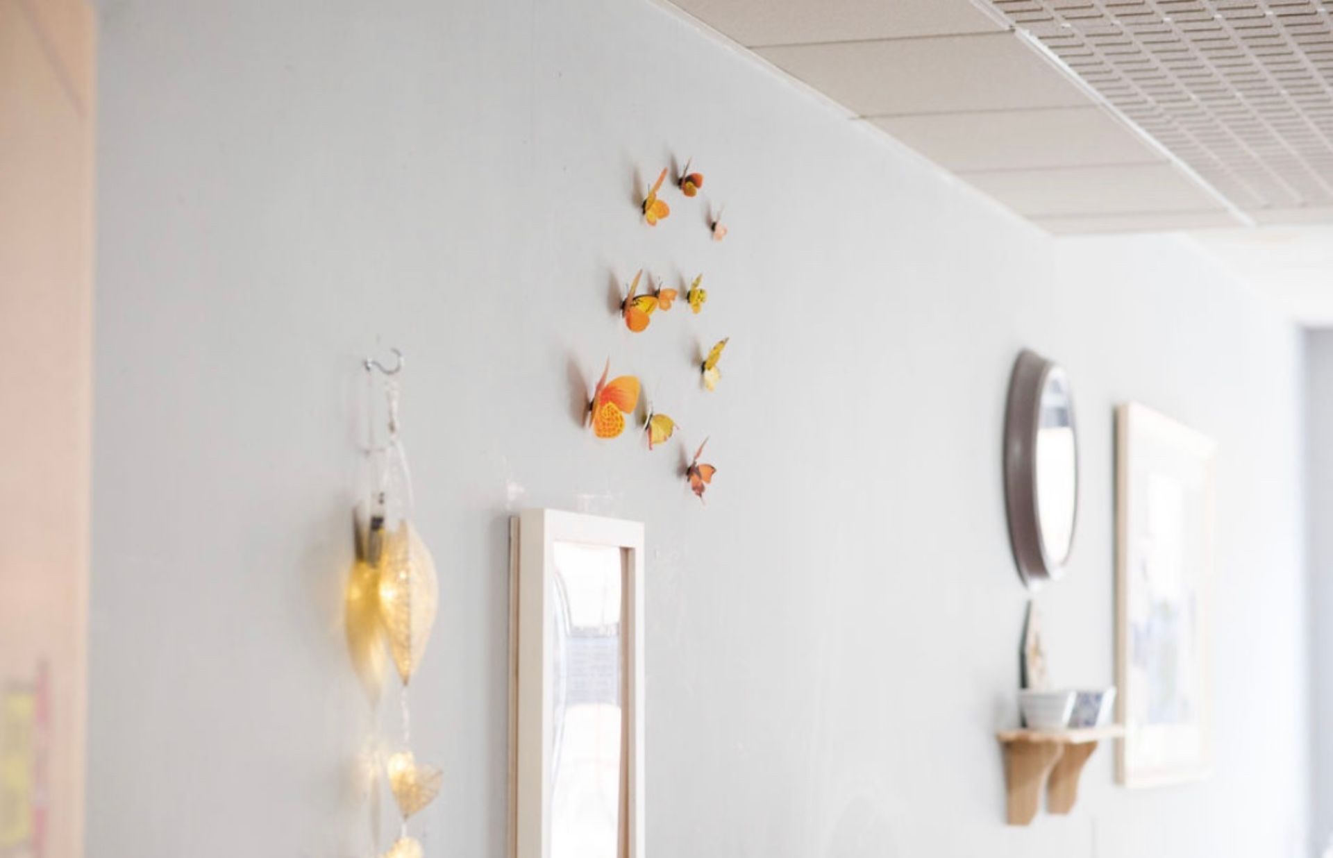 a hallway with a clock on the wall and butterflies on the wall