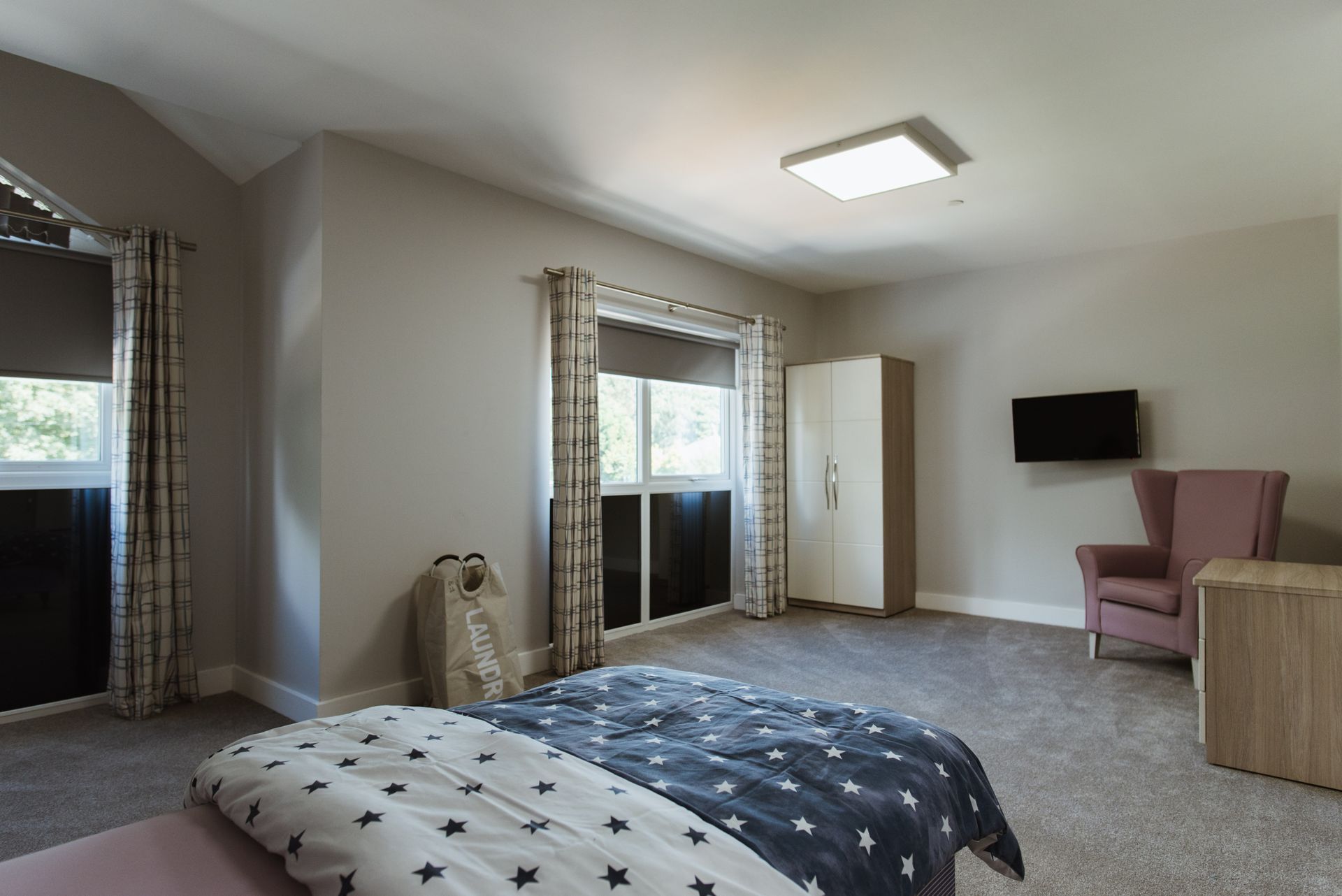 a bedroom with a bed a chair and a television