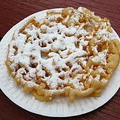 A paper plate topped with a funnel cake covered in powdered sugar.