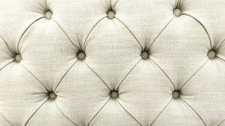 Cream tufted upholstered fabric with diamond stitching and button details