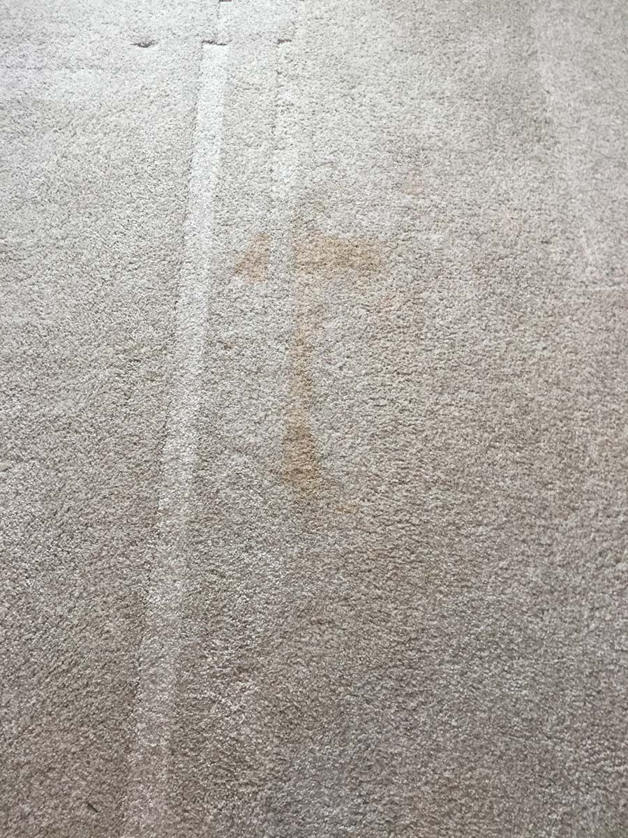 Close-up of a light gray textured concrete surface with a faint vertical streak.