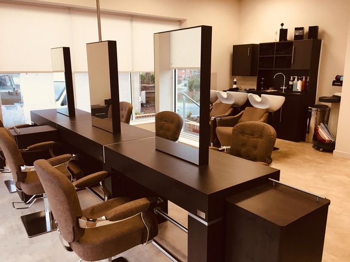 A-modern-hair-salon-featuring-a-long-styling-station-with-three-mirrors