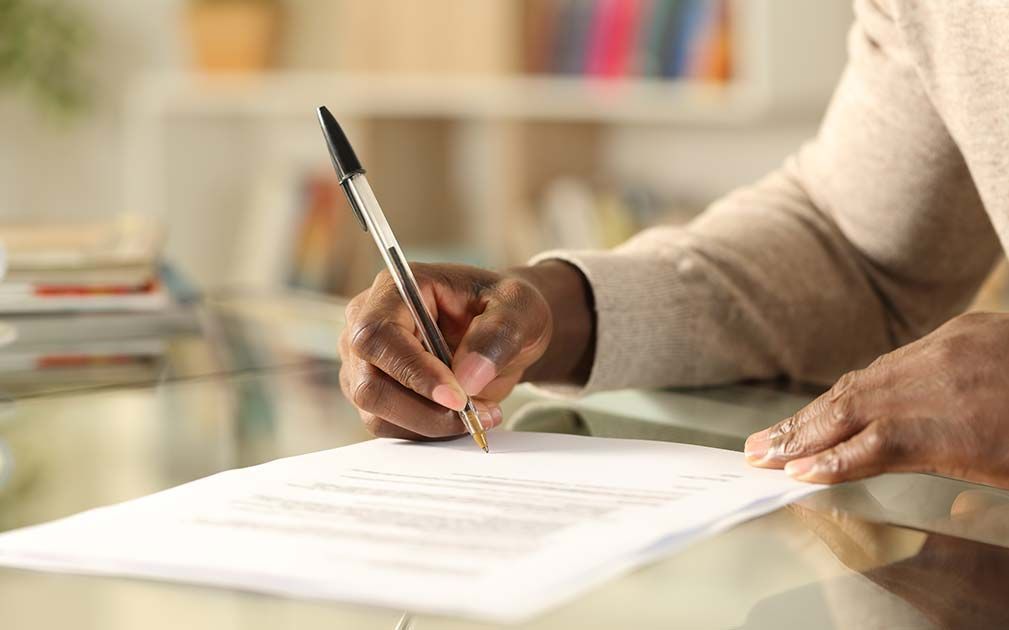 a person is writing on a piece of paper with a pen