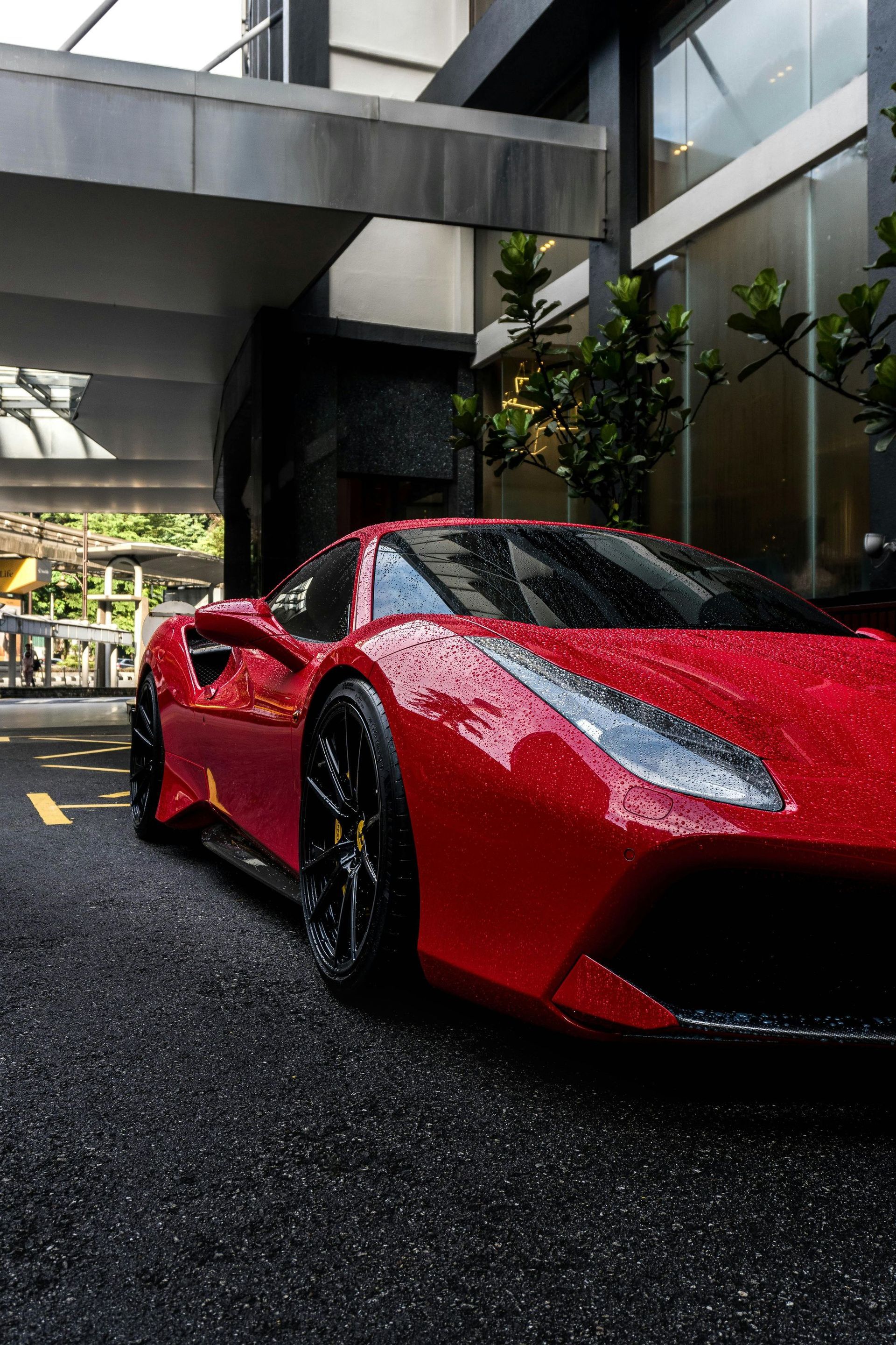 A red sports car is parked in front of a building.