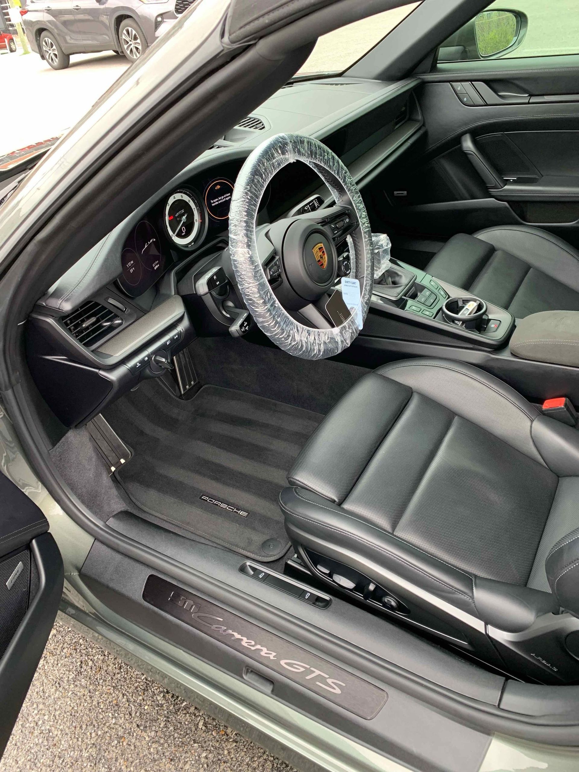 The interior of a porsche 911 turbo s is shown with the door open.