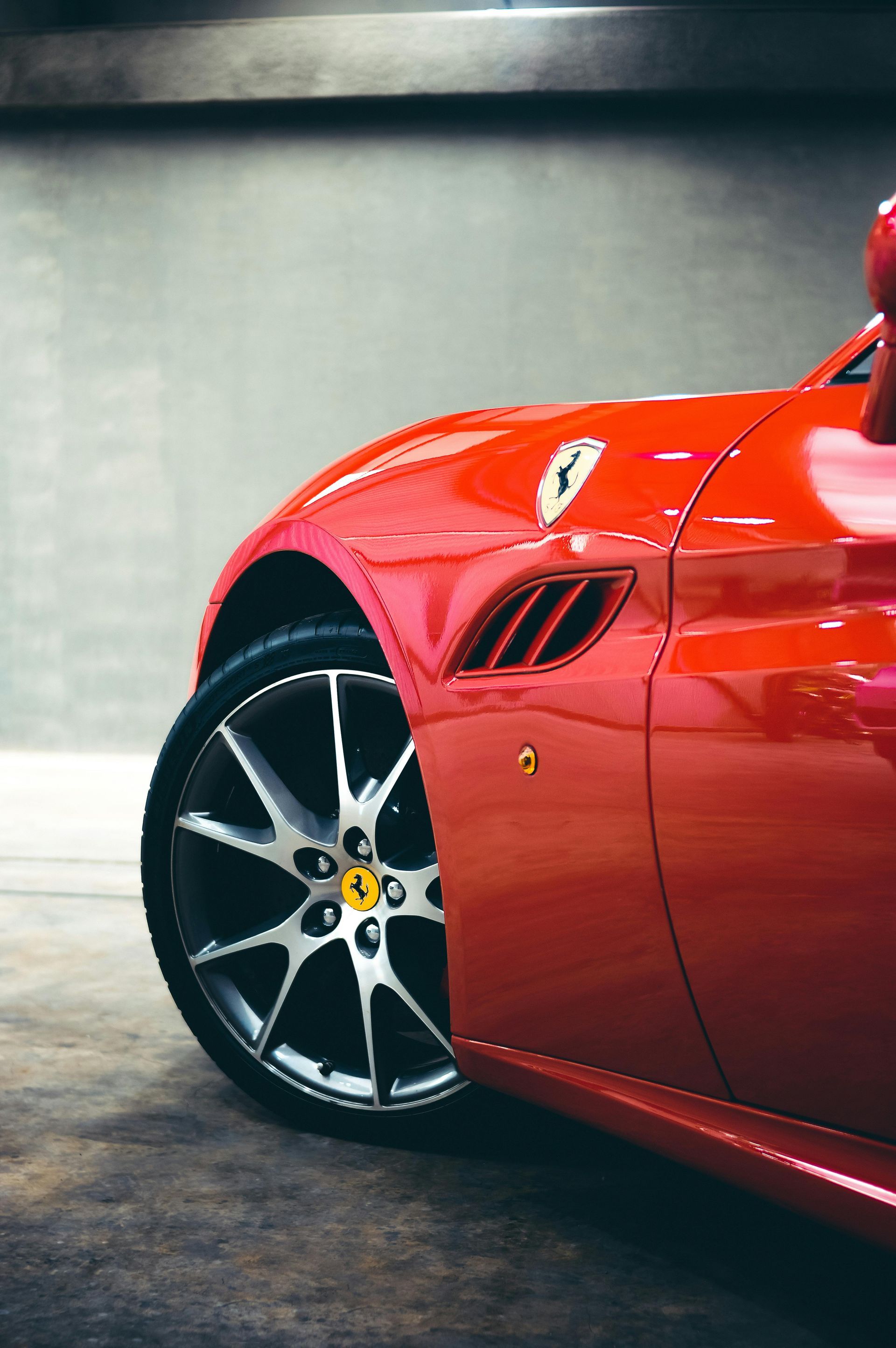 A red ferrari sports car is parked in a garage.