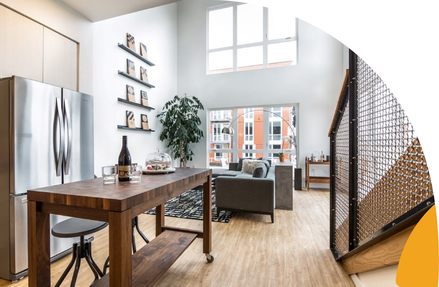 Modern loft apartment with wood floors, dining table, sofa, and large windows