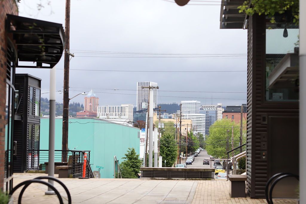 Covered walkway overlooking a cityscape with mountains in the distance under a cloudy sky
