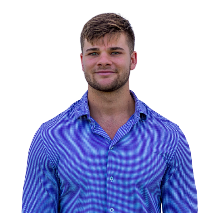 A person with short brown hair and light stubble wears a textured blue button-down shirt against a white background.