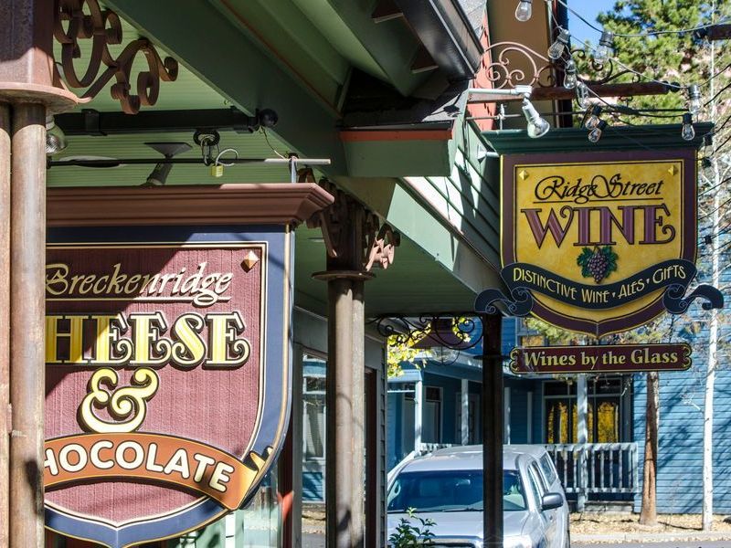 Signs for Breckinridge Cheese & Chocolate and Ridge Street Wine on a building's exterior.