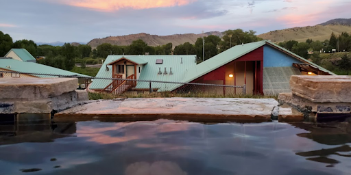 There is a large pool of water in front of a house in Hot Sulphur Springs Resort & Spa Colorado