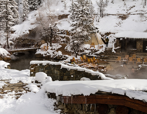 A snowy landscape with a bridge in the foreground in Strawberry Park Hot Springs Colorado