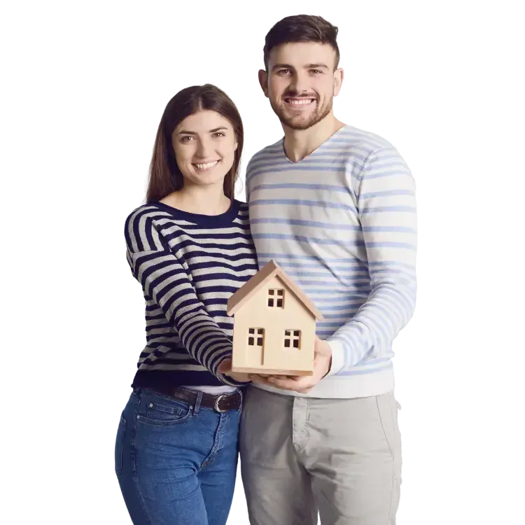 A couple holding a wooden house model, smiling, on a white background.