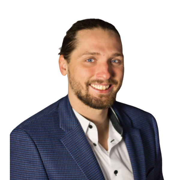 A smiling person with a beard and tied-back hair, wearing a white shirt and a blue patterned blazer against a white background.