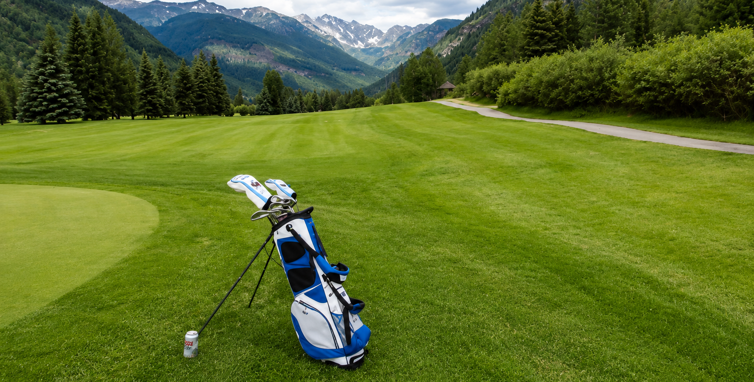 Golf bag and clubs on a green course with mountains in the background in Vail, CO