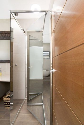 A Bathroom With a Mirror and a Wooden Door — Precision Shower Screens & Wardrobes In Yarrawonga, NT