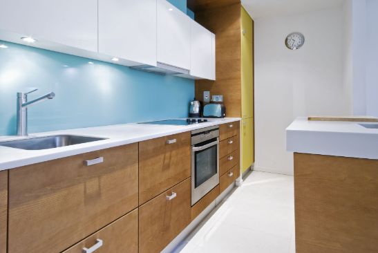 A Kitchen With Wooden Cabinets and White Counter Tops — Precision Shower Screens & Wardrobes In Yarrawonga, NT
