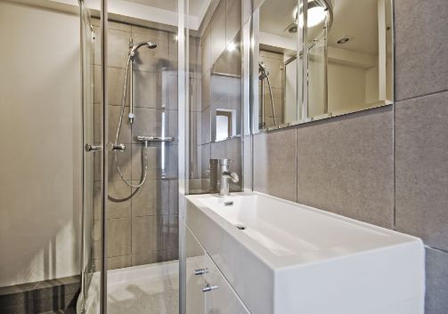 A Bathroom With a Sink, Shower and Mirror — Precision Shower Screens & Wardrobes In Yarrawonga, NT