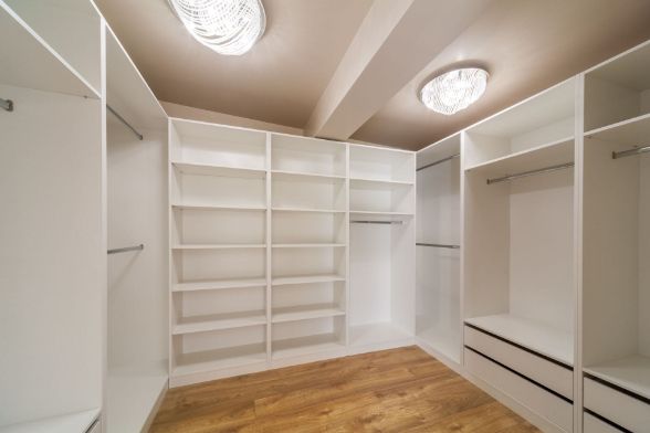 An Empty Walk in Closet With Lots of Shelves and Drawers — Precision Shower Screens & Wardrobes In Darwin, NT