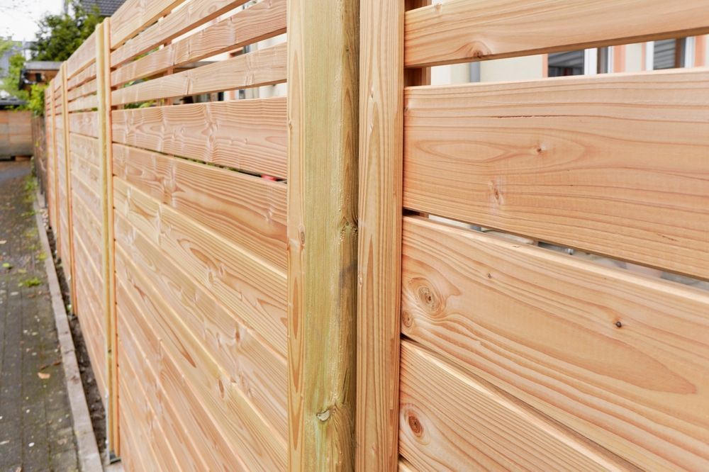 Wooden horizontal slat fence. Light brown wood, installed outdoors.