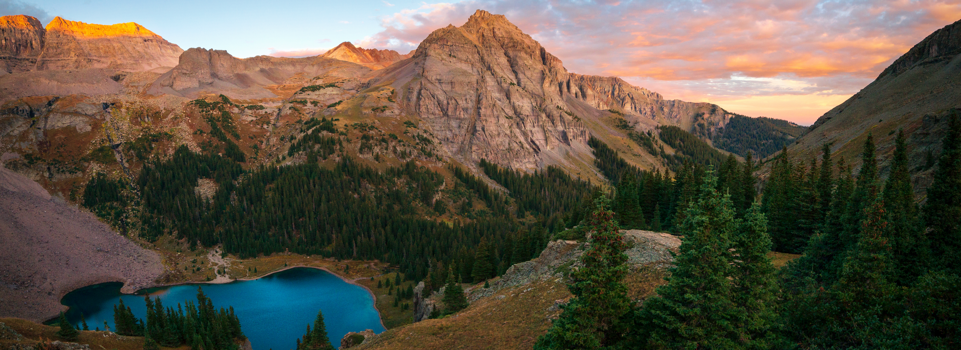 There is a lake in the middle of the mountains surrounded by trees.
