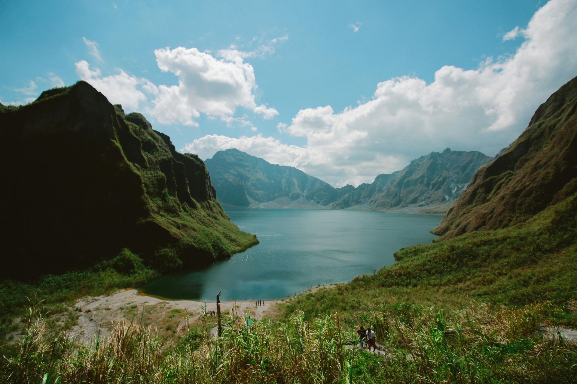A lake surrounded by mountains on a sunny day