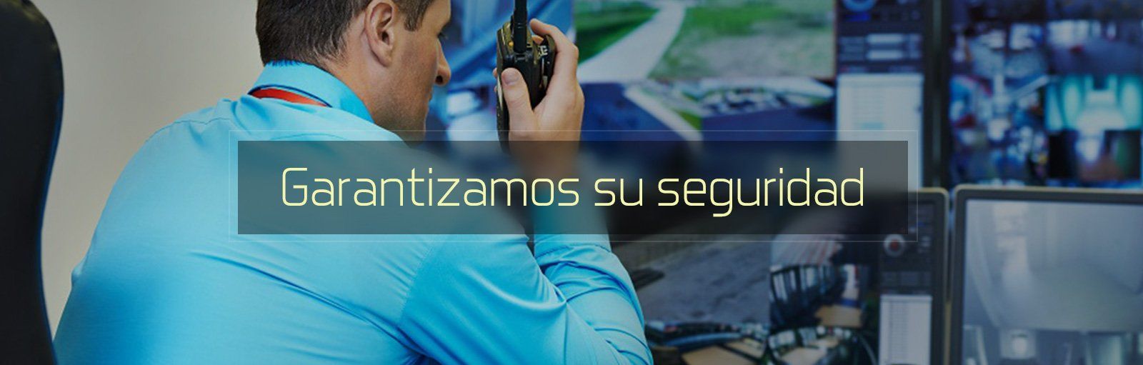 Técnico con uniforme azul usando una radio en una estación de monitoreo de seguridad 