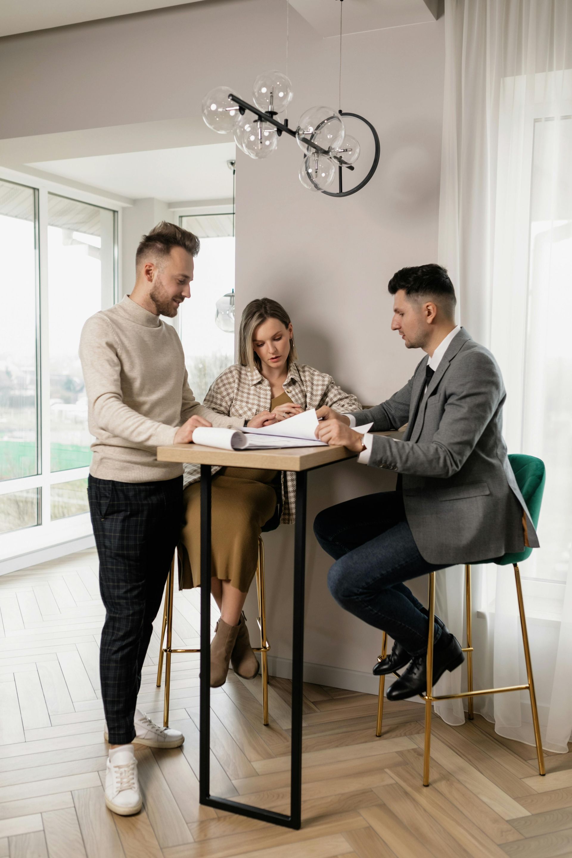 Couple reviewing documents with a professional in modern home setting.