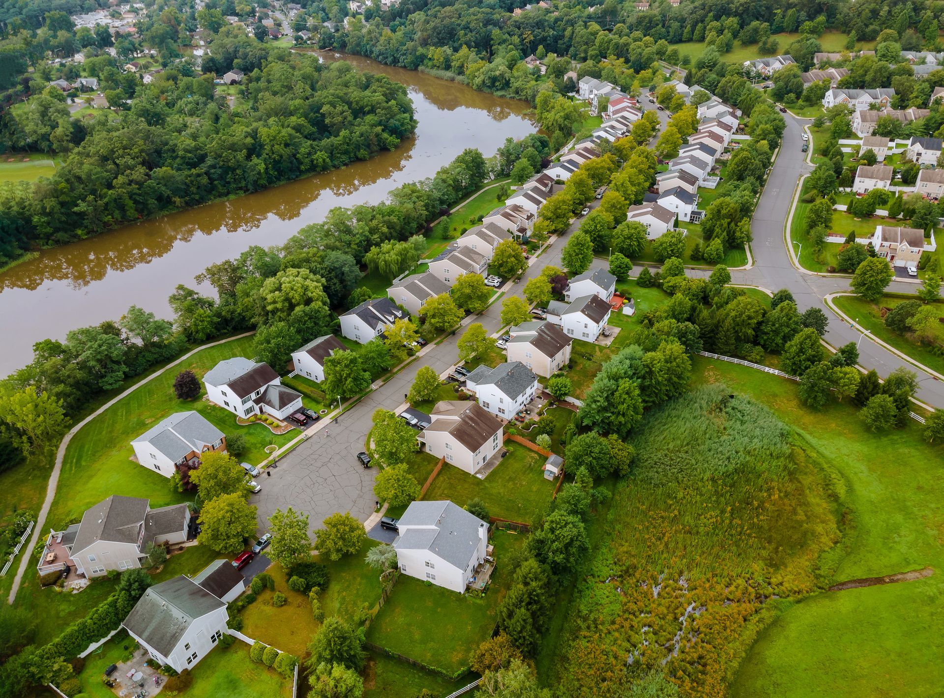 An aerial view of a residential area with a river running through it.