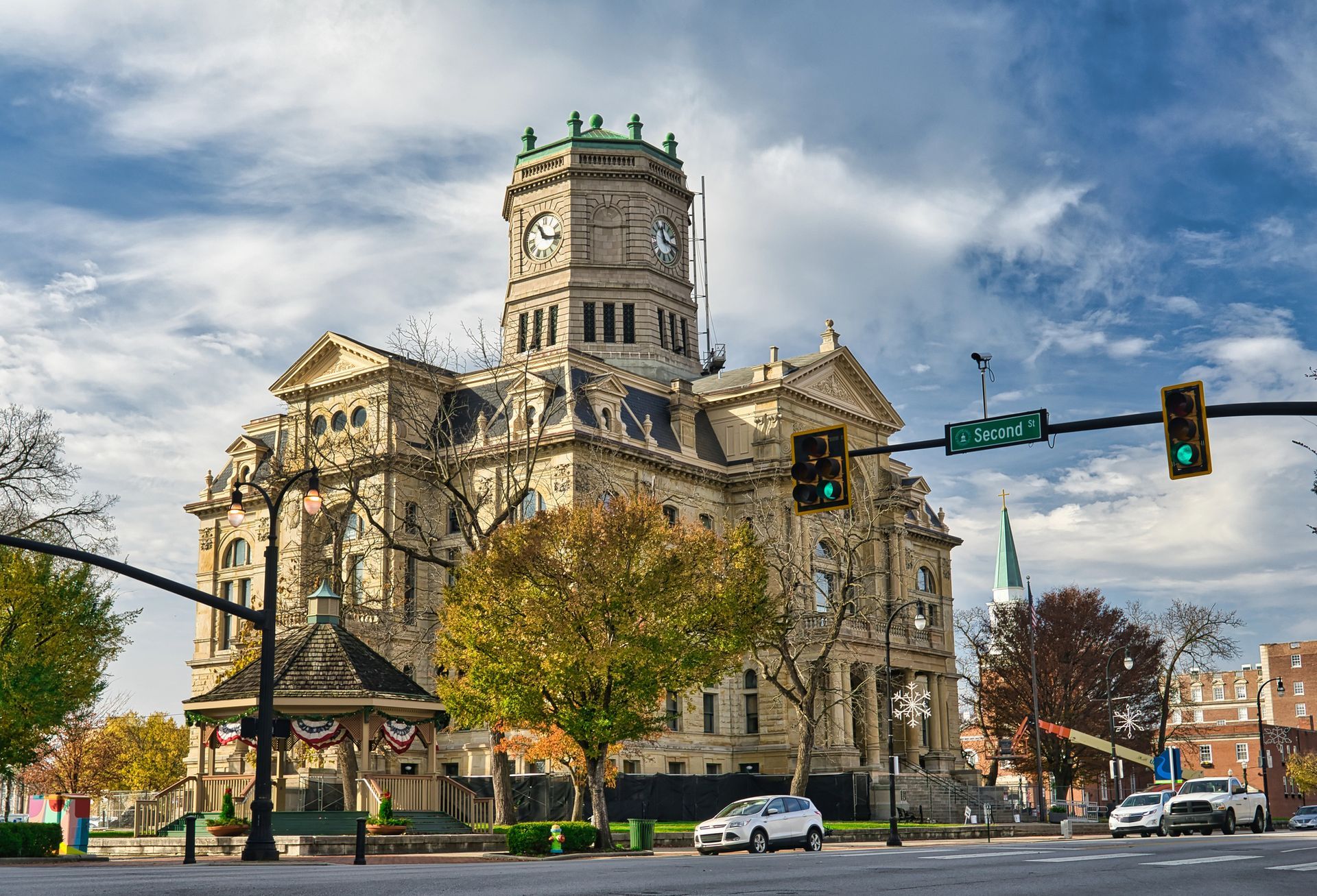A large building with a clock tower in the middle of a city.