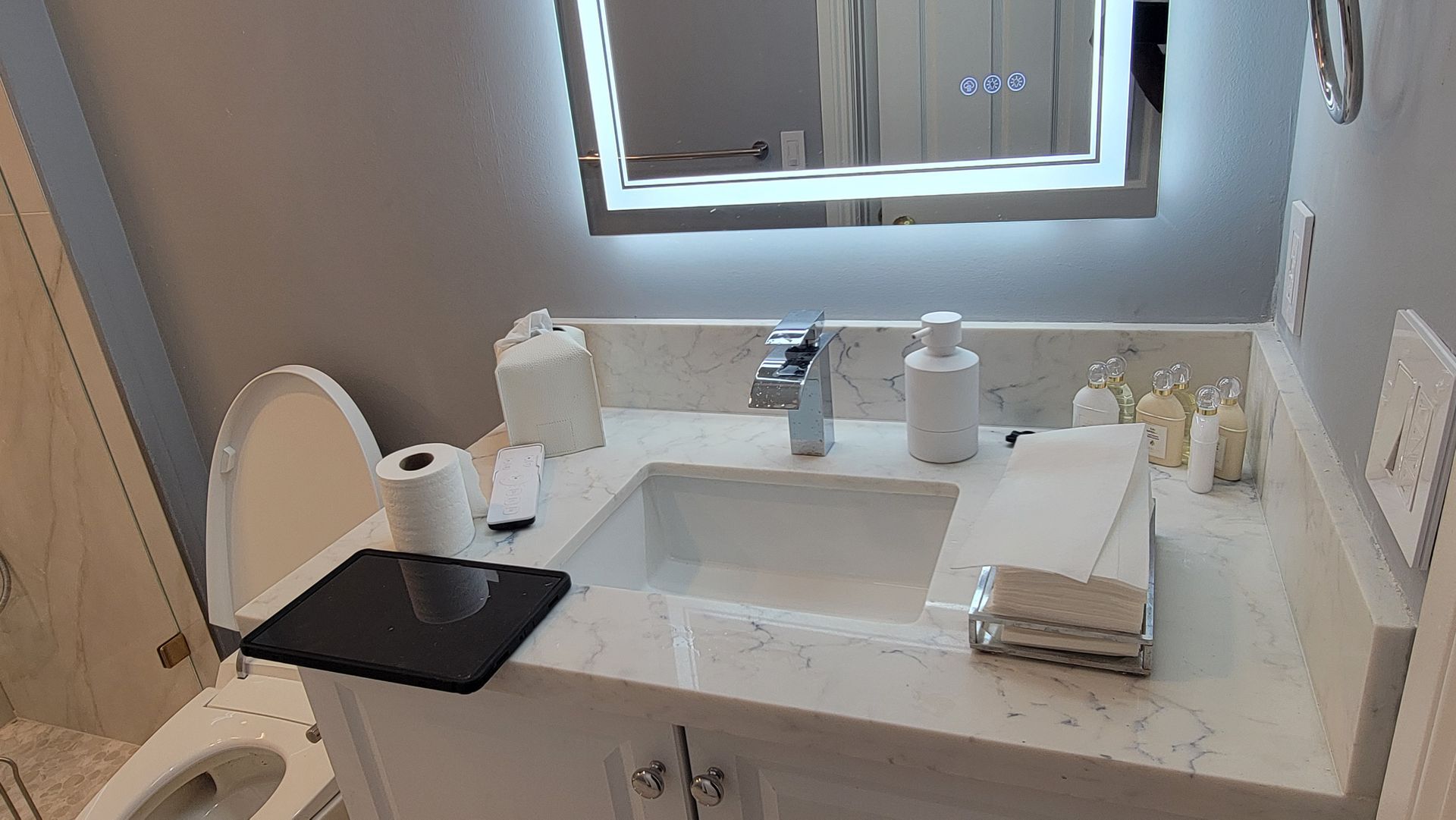 Bathroom vanity with sink, mirror, and neatly arranged towels and toiletries