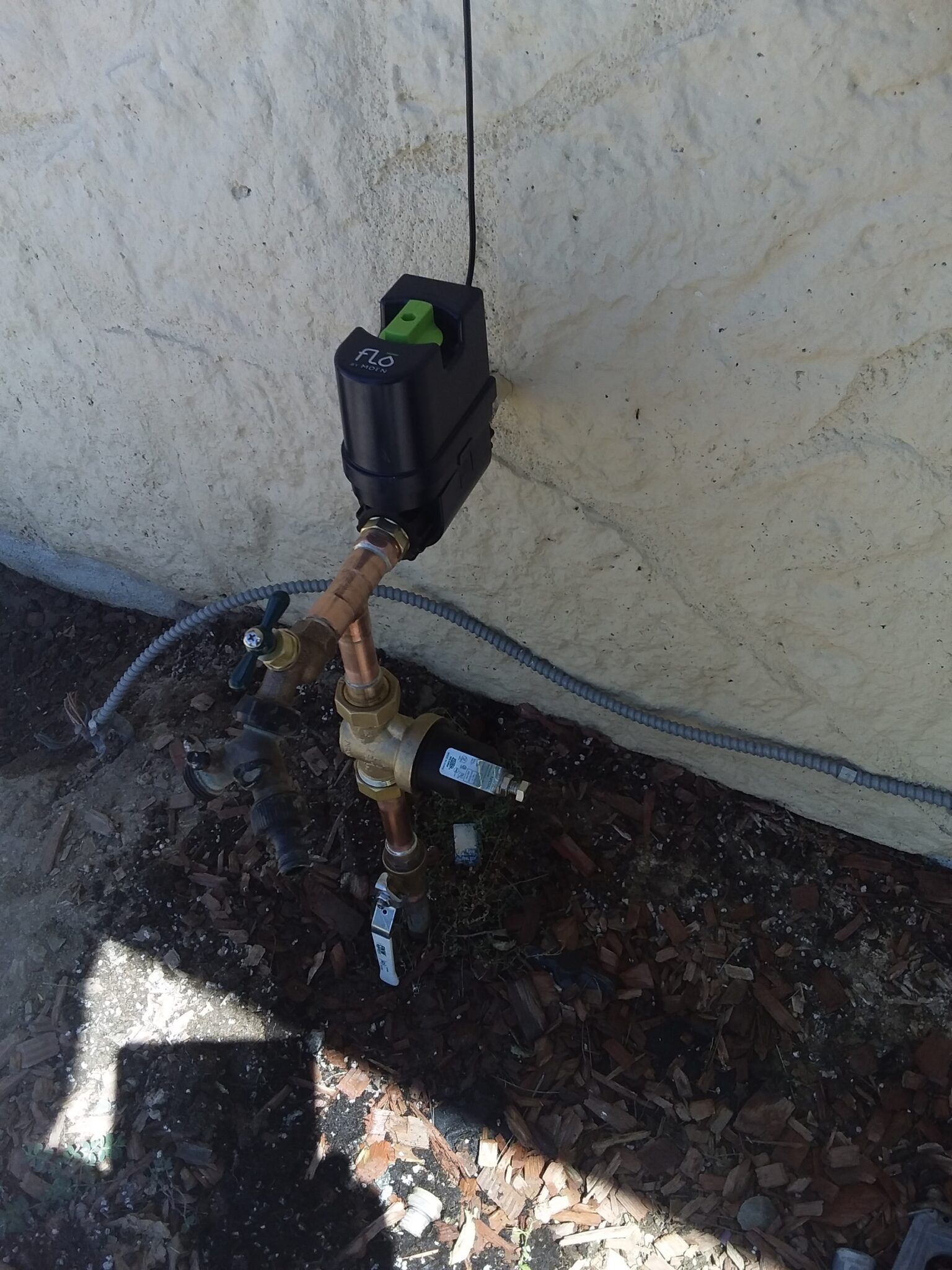 Leaking pipe joint with water dripping, overlaid by a blue inspection target graphic and warning icon