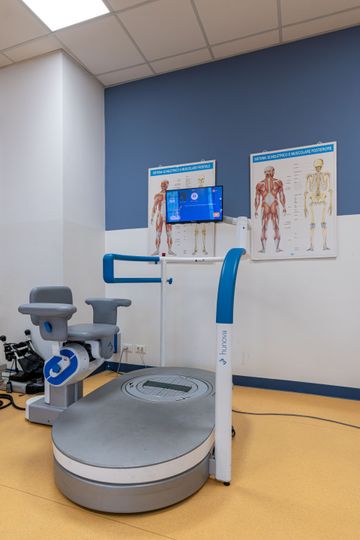 Scanner per diagnostica per immagini accessibile, con piattaforma per sedia a rotelle e monitor, colore bianco e blu.