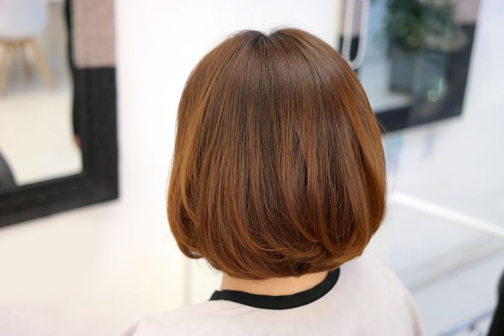 A Woman With Short Brown Hair Is Sitting In Front Of A Mirror — L'Auranda Hair Salon In Evan St. Mackay, QLD