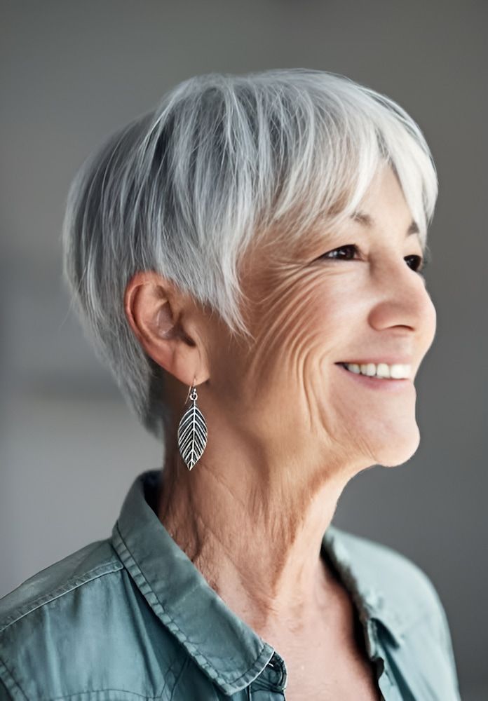 An Older Woman With Gray Hair and Earrings is Smiling —  L'Auranda Hair Salon In  Evan St. Mackay, QLD