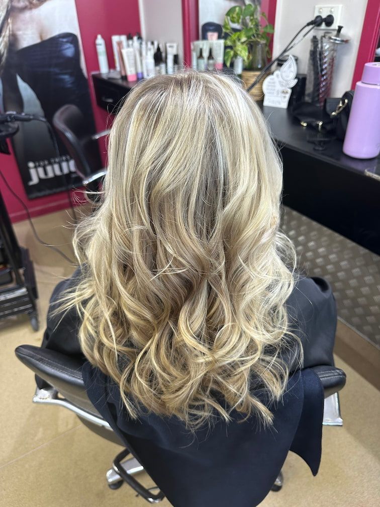 A Woman With Long Wavy Blonde Hair Has Had Highlights In A Salon —  L'Auranda Hair Salon In  Evan St. Mackay, QLD