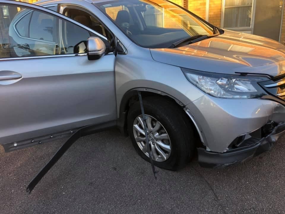 A Silver Car With A Damaged Front End Is Parked On The Side Of The Road — Trade & General Towing In Sandgate, NSW