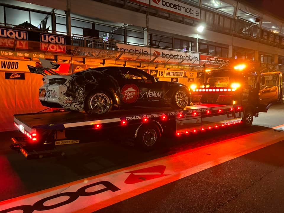 A Car is Being Towed by a Tow Truck at Night — Trade & General Towing in Lake Macquarie, NSW
