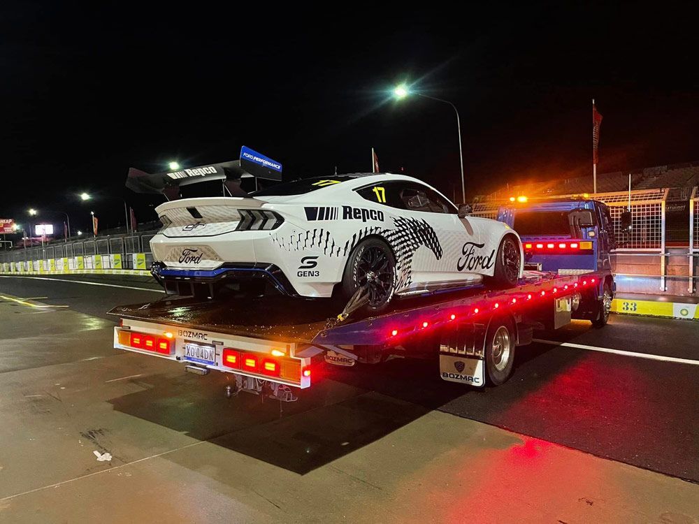 A White Ford Mustang is Being Towed by a Tow Truck — Trade & General Towing in Cessnock, NSW